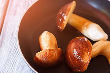 Black pan with mushrooms. Brown mushrooms on frying pan. Ingredient for delicious ragout. Mushrooms gathered in the forest.
