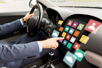 man driving car with menu icons on board computer
