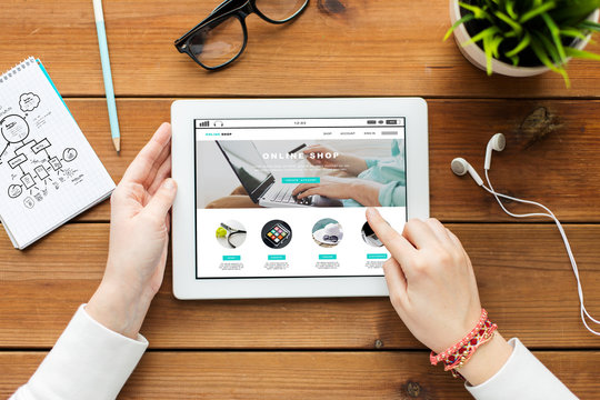 close up of woman with tablet pc on wooden table