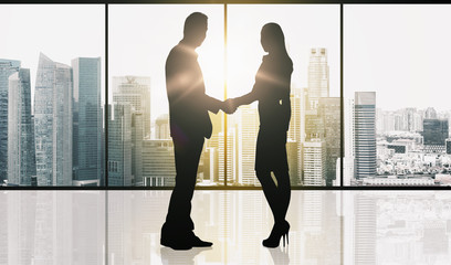business partners silhouettes making handshake