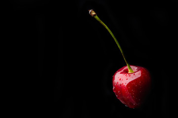 Fresh juicy cherry isolated on a black background