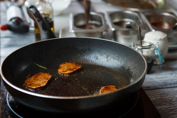 Brown meat on frying pan. Whole pepper and dark meat. Preparation of veal medallions. Meat that smells tasty.