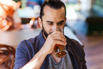 happy man drinking beer at bar or pub