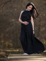 Young woman in evening dress on the pier