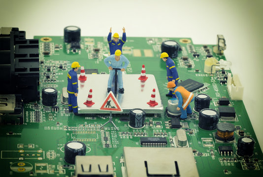 group of mini workers are try to repair a chip on mainboard