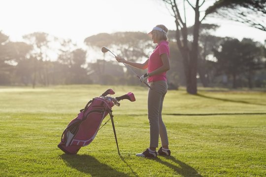 Side view of woman carrying golf club 
