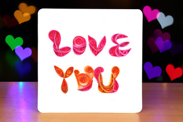 Handmade Love You Card on the Background of Heart Shaped Bokeh
