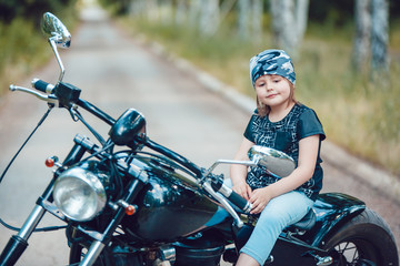 Fototapeta na wymiar Little girl on a motorcycle.