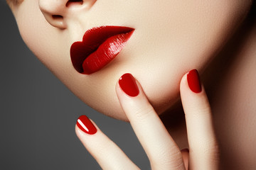 Beauty fashion model face. Manicured hand with red nails. Red lips and nails. Beautiful woman with...