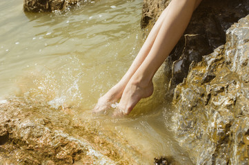 girl wets feet in water