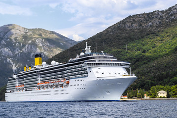 sea liner runs along the mountainous coast line
