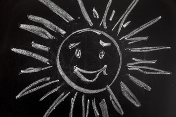 Blackboard with drawing smiling sun
