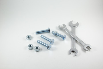 Spanners, bolts and nuts on a white background