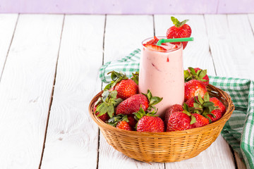 fresh strawberries and smoothies in a basket on table