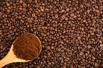 coffee beans and ground coffee in wooden spoon