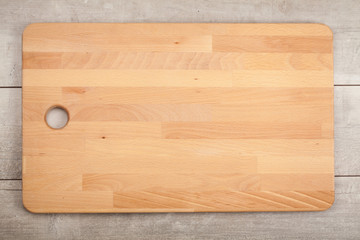 Obraz premium Wooden cutting board on old wooden table.Top view.