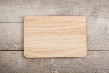 Wooden cutting board on old wooden table.Top view.