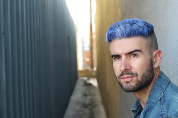 Fototapeta premium Close-up portrait of a beautiful young man with blue hair. Men's beauty, fashion.