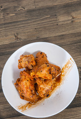 Sticky Chinese Chicken Wings with soy sauce and sesame on wooden table