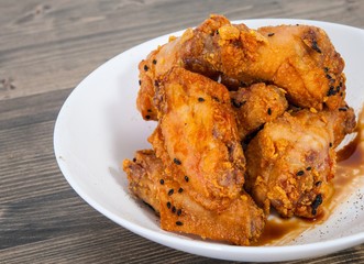Sticky Chinese Chicken Wings with soy sauce and sesame on wooden table