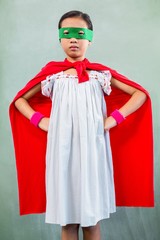 Girl dressed as superhero in classroom - obrazy, fototapety, plakaty