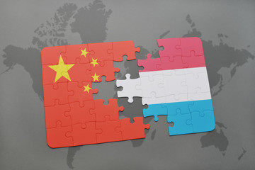 puzzle with the national flag of china and luxembourg on a world map background. © luzitanija