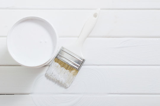 Bank paints and brush on a white wooden background