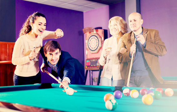 Group of adults playing pool.