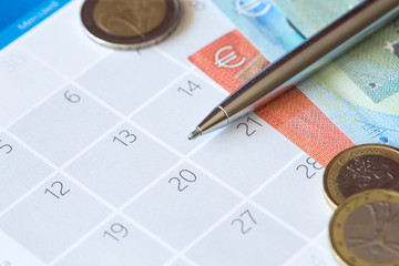 Penna e denaro contante su calendario