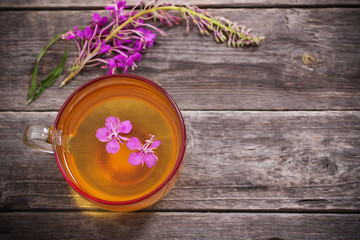 cup of tea with willow-herb on wooden background