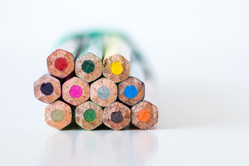 Pastelli colorati legati con elastico su superficie chiara © errem