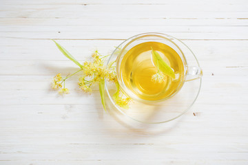 cup of tea and linden flowers on a wooden background