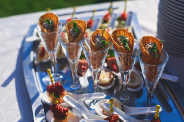 Beautifully decorated catering banquet table with different food snacks and appetizers with sandwich, caviar, fresh fruits on corporate christmas birthday kids party event or wedding celebration