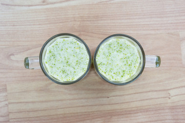 Two glasses of smoothie s from above on a wooden background