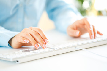 Woman office worker typing on the keyboard