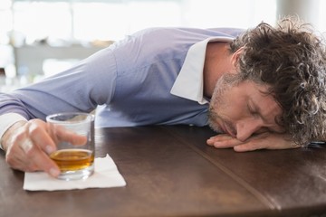 Obraz premium Drunken man sleeping on a bar counter