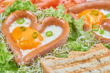Heart shaped sausages with fried eggs