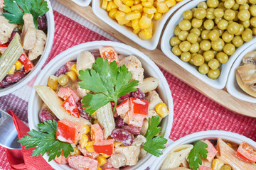 Chicken and vegetable salad in white bowls. Salad ingredients