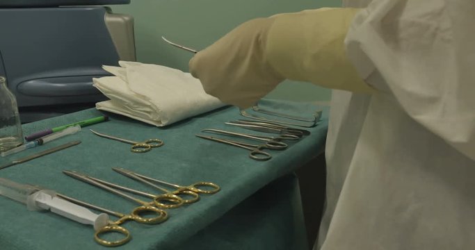 The nurse assistant prepares medical instruments , devices before surgery. Equipment, Instruments, Sterilize.