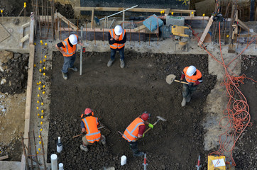 construction site workers leveling cement in building site