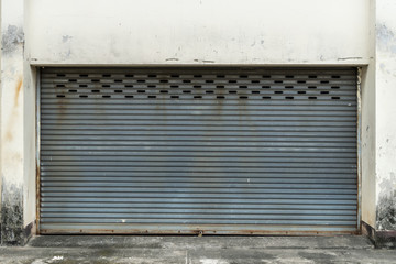 Fototapeta na wymiar Old gray roller shutter door