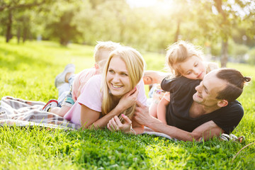 Naklejka na ściany i meble Family playing in the park on the grass