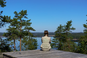 woman sitting and looking at the river from the top of the mountain