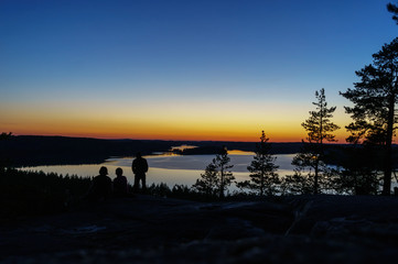 Sitting at sunset, at the edge of the cliff and looking out into the distance to the lake