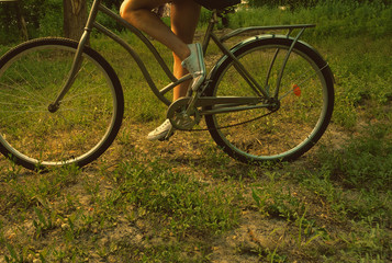 Fototapeta na wymiar Retro shot of young hipster woman on city bike fixie at the park. Summertime. Freedom teenager with her happy vacation travel.