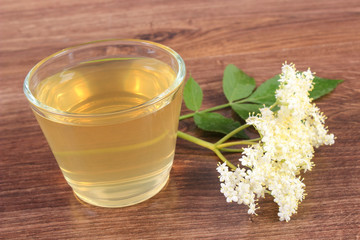 Fresh healthy juice and elderberry flowers on rustic board