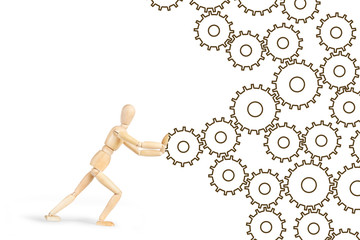 Man pushing the cogwheels to make mechanism working. Abstract image with a wooden puppet