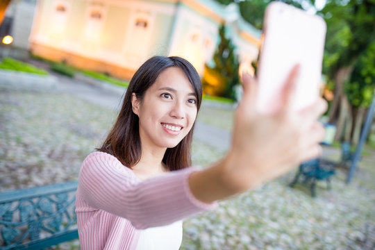 Woman taking selfie by mobile phone in Macau