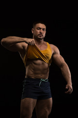 handsome muscular bodybuilder posing on a black background