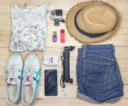 Outfit of traveler, student, teenager, young woman. Overhead of essentials for modern young person. Different objects on wooden background.
